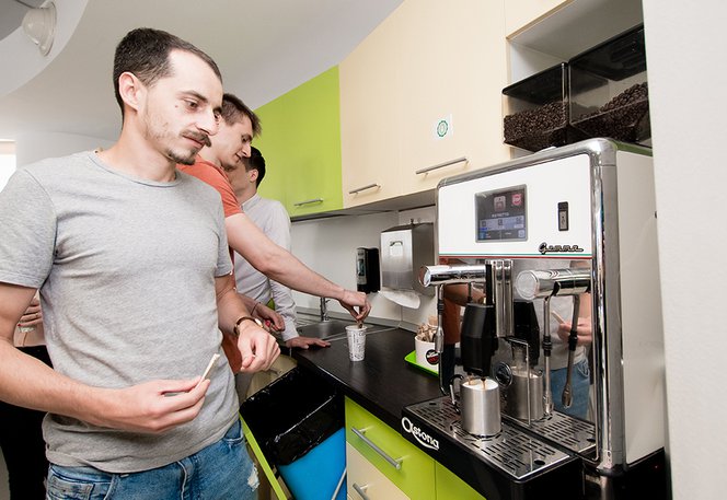 Centric Iasi team of software developers getting coffee in the kitchen